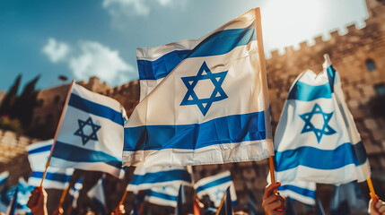 Fototapeta premium Crowd waving israeli flags in front of the western wall in jerusalem