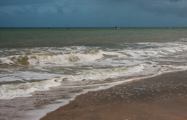 Surf along the beach at Inhassoro in Mozambique against an ominous stormy sky