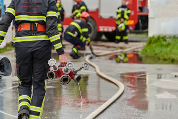 In a dynamic display of synchronized teamwork, firefighters hustle to carry, connect, and deploy...