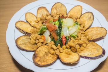 Indonesian traditional food: stir fried napa cabbage (korean cabbage), with tomato and chili, diced tempeh (Indonesian fried soy patties), and crispy fried eggplant