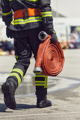 In a dynamic display of synchronized teamwork, firefighters hustle to carry, connect, and deploy...
