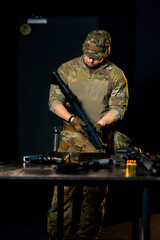 in a professional shooting range professional fighter assembles a NATO assault rifle