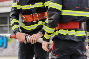 In a dynamic display of synchronized teamwork, firefighters hustle to carry, connect, and deploy...