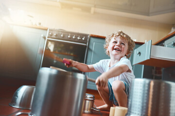 Happy, child and drums on pots in kitchen as creative talent, music or sound as musician of...