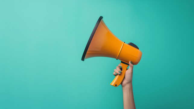 A vibrant yellow megaphone is held against a bright teal background, symbolizing bold communication and announcements.