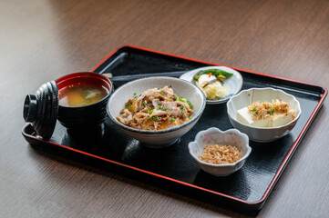 A delicious Japanese meal with rice, pork, and various side dishes.