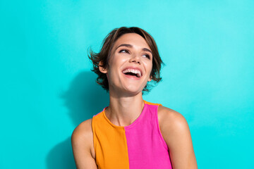 Photo of dreamy positive woman wear pink orange top laughing looking empty space isolated teal color background