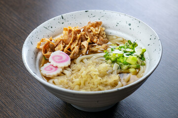 A bowl of udon noodles with pork and tempura