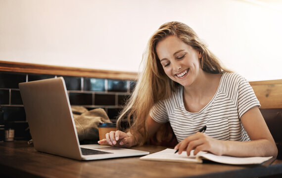 Woman, smile and study at cafe with laptop as university student for elearning or online education. Female learner, happy and satisfied with writing or revision and research for college exams