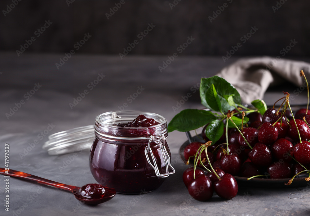 Sticker cherry jam and fresh berries on the table