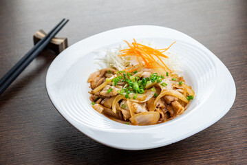 A plate of food with pork, onions, and carrots.