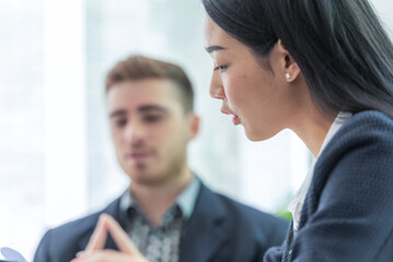 A professional woman and man are having a serious discussion in an office setting.