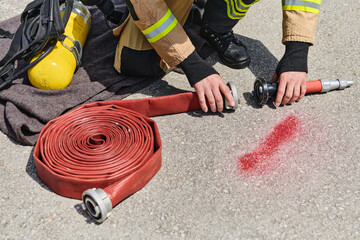 Professional Firefighter Cleaning Up Fire Hose After Extinguishing Blaze