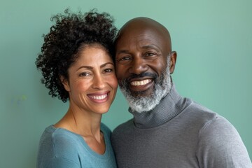 Portrait of a grinning multiethnic couple in their 40s showing off a thermal merino wool top isolated on pastel green background