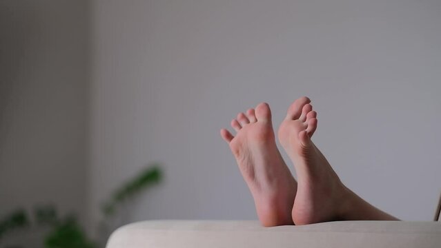 legs of a 12 year old child, legs on the sofa in a cozy home environment move merrily