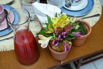 utensils on the table, utensils on the kitchen, flowers in vase, tulips in the kitchen, tulips in a vase, juice jugs, modern juice jugs, glass jugs, glass bowls, flower vase, white napkins
