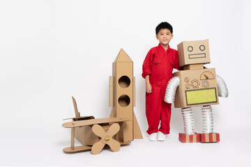 Asian little boy standing with toy robot paper diy, cardboard airplane and rocket isolated on white...