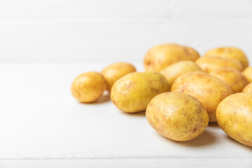 Young potatoes. Fresh potatoes  on a wooden background.Harvesting collection. organic, freshly dug potatoes. Agricultural background. Vegan. Vegetables.Place for text.Copy space