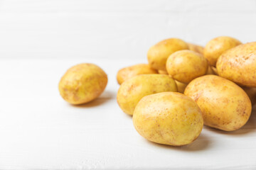 Young potatoes. Fresh potatoes  on a wooden background.Harvesting collection. organic, freshly dug potatoes. Agricultural background. Vegan. Vegetables.Place for text.Copy space