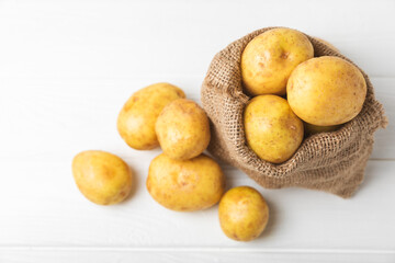 Young potatoes. Fresh potatoes  on a wooden background.Harvesting collection. organic, freshly dug potatoes. Agricultural background. Vegan. Vegetables.Place for text.Copy space