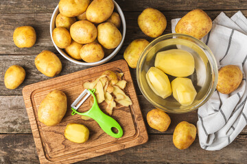 Young potatoes. Raw potatoes and knife on a wooden background.Peel potatoes.Harvesting collection. organic, freshly dug potatoes. Agricultural background. Vegan. Vegetables.Place for text.Copy space