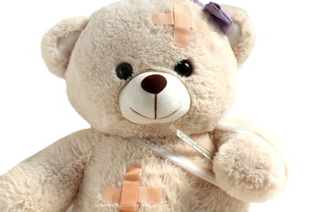 Teddy bear sits on a white background wounded.