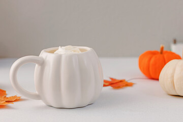 Hot drink in pumpkin shaped mug, fall still life composition