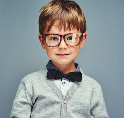 Fashion, glasses and portrait of boy geek in studio isolated on blue background for intelligence....