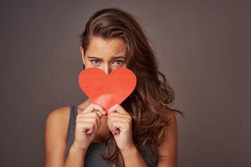 Portrait, love and woman with paper heart for romance, support and donate isolated on studio background. Face, care and model with sign for valentines day, kindness and hide on social media emoji