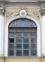 A large arched window of an ancient mansion