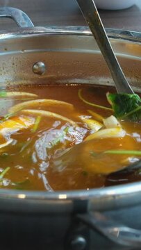 broth with vegetables Stirred ladle chicken with noodles and potatoes cold soup in a small saucepan on the gas stove near the window