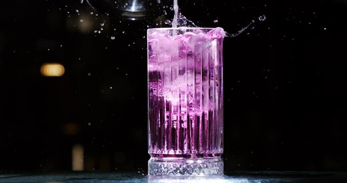 Super slow motion close up of bartender is preparing alcoholic cocktail in transparent glass for customer in bar or disco club at 1000 fps.