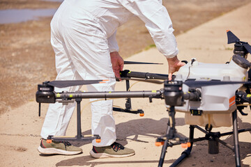 A male worker setting up the agro drone for flying over fields.