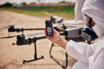 A male operator holding and using a hand-held anemometer tested the air flowing before starting the...
