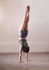 Woman, handstand and yoga exercise in fitness studio of space, body and wellness for health. Back of person, upside down for balance or pilates, agility and strong core for power with flexibility © EmilLL/peopleimages.com