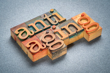 anti aging - text in retro letterpress wood type stained by color inks, lifestyle concept