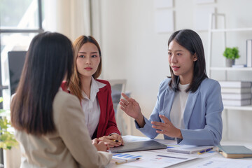 Three businesswomen having a meeting in a modern office, discussing important matters with determination and collaboration.