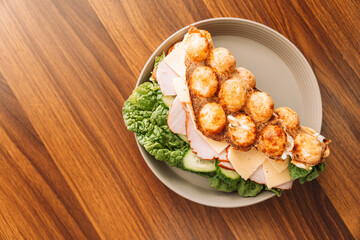 Sandwich bubble waffle with meat, cheese and herbs in a plate.