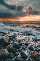 Obraz premium An endless sea with rocks on the shore, dark clouds in the sky at sunset. Waves crash against stones in a distant