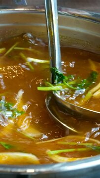 broth with vegetables Stirred ladle chicken with noodles and potatoes cold soup in a small saucepan on the gas stove near the window