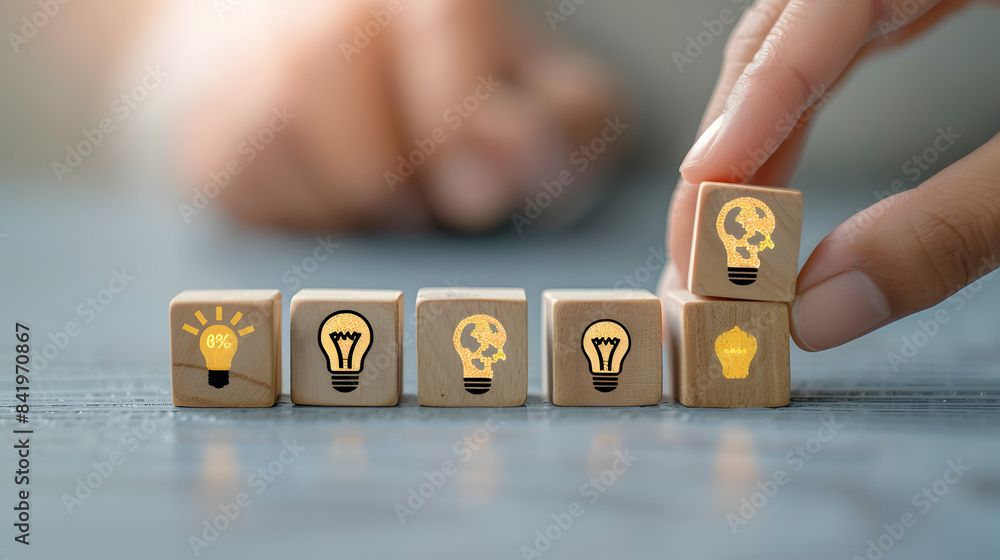 Poster a hand placing wooden blocks with icons of heads and lightbulbs on them in a row. symbolizing the id