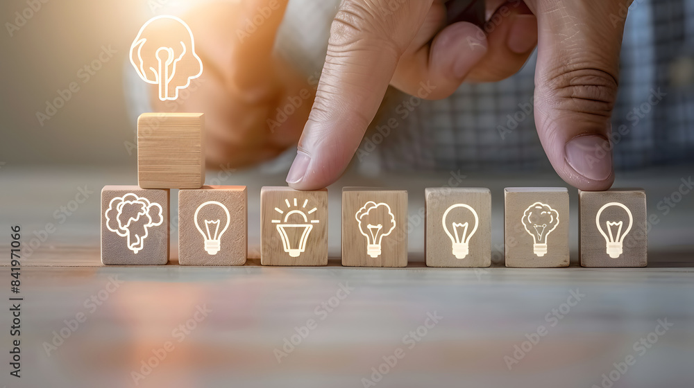 Poster a hand placing wooden blocks with icons of heads and lightbulbs on them in a row. symbolizing the id