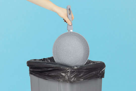 throw the frying pan in the trash, outstretched hand with the frying pan in front of the trash can