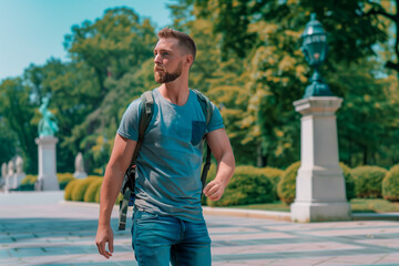 Man walking in park with backpack. Man with a backpack strolling through a lush, green park on a sunny day, enjoying the outdoor scenery and fresh air.