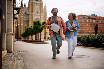 Fototapeta premium Carefree mature couple laughing while sightseeing in city.