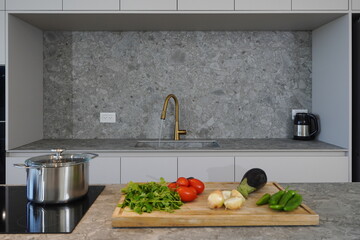 modern kitchen with vegetables on cutting tray