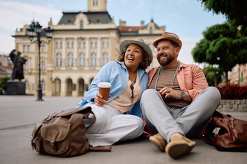 Happy mature couple of travelers relaxing on city street. Copy space.