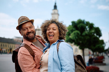 Carefree mature couple having fun during their travel and looking at camera.
