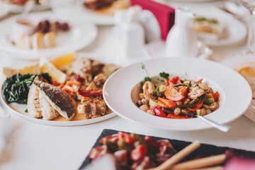 food on a white tablecloth. many different dishes arranged on the table view of the chef in a restaurant. 