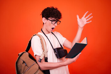 Vacations and holidays. Funny lost tourist with a backpack. Orange background.